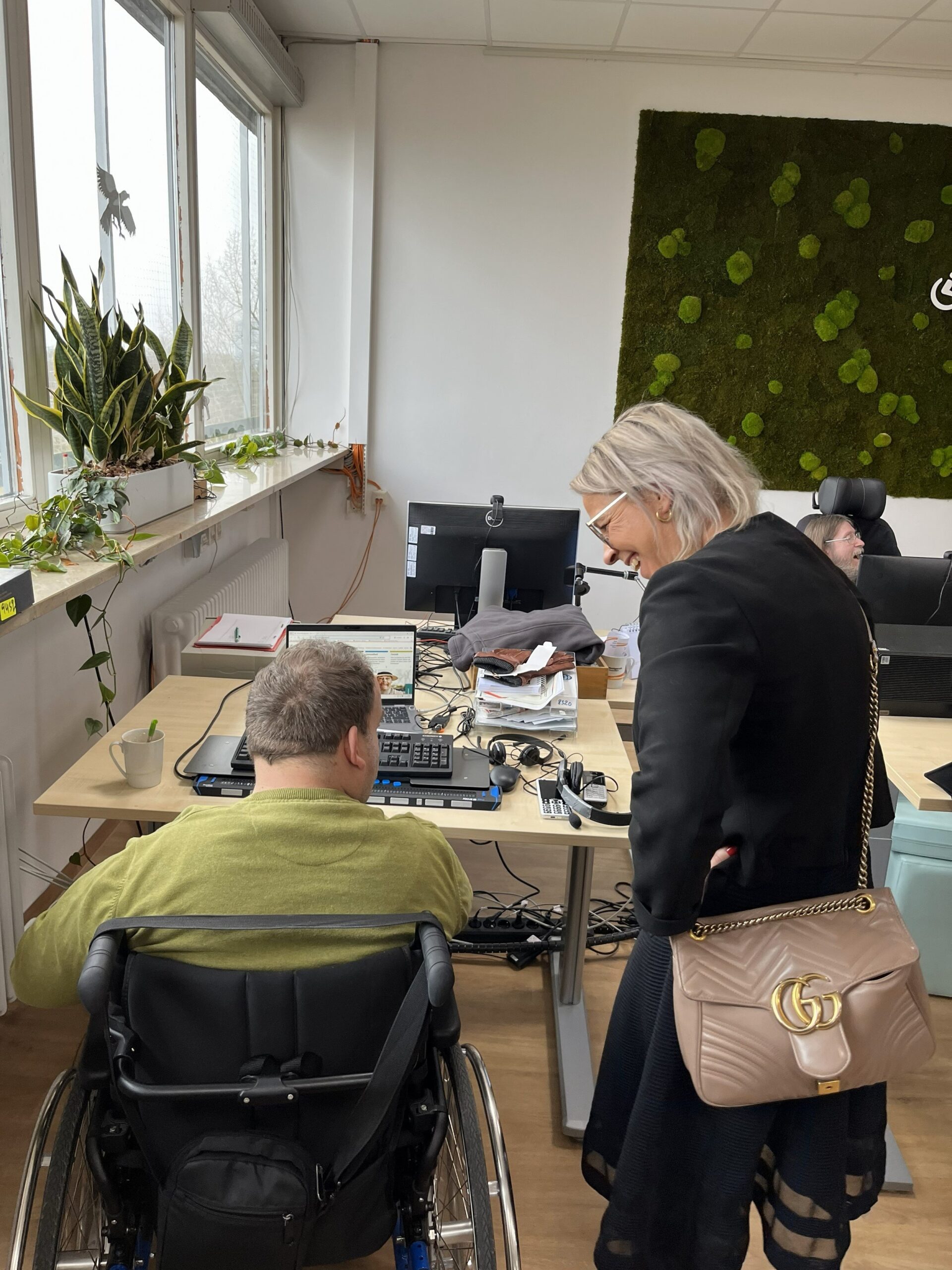 Eine Person steht neben einer Person im Rollstuhl