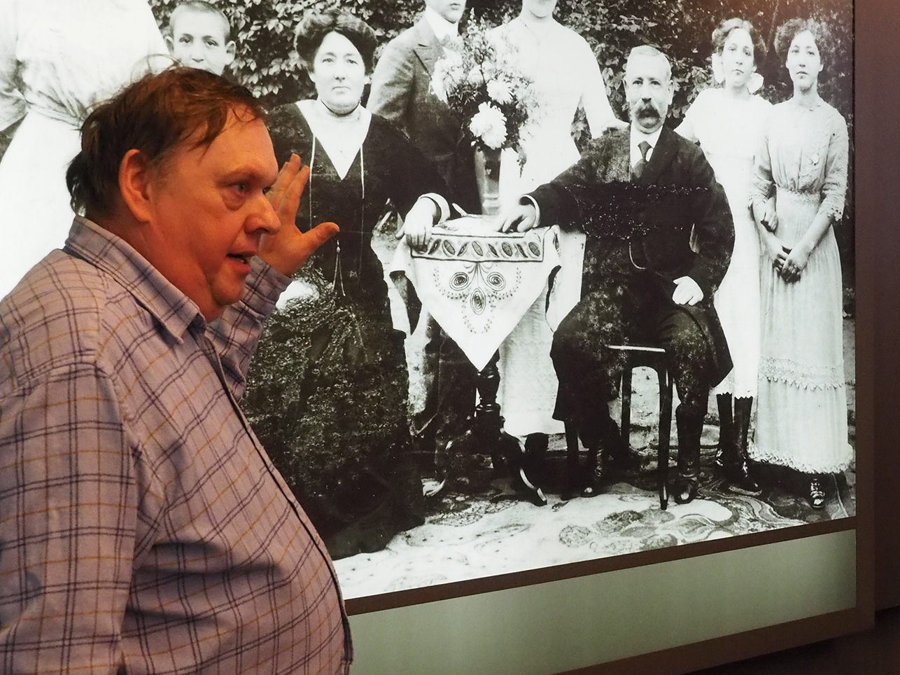 Ein Mann zeigt ein Bild und erzählt über die Zeit des 2. Weltkrieges