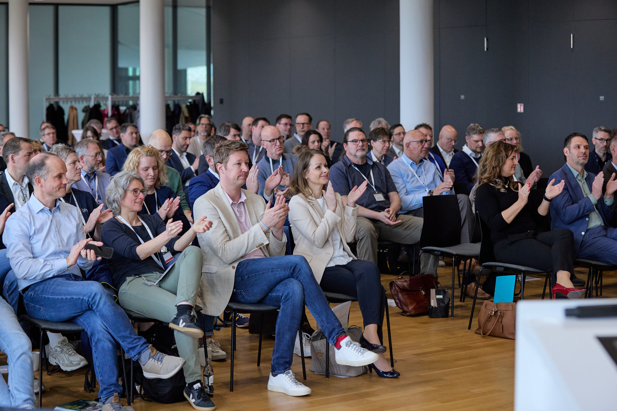 Publikumsszene beim Mitglieder:Dialog 2026 der BAG WfbM. Die Teilnehmenden applaudieren.